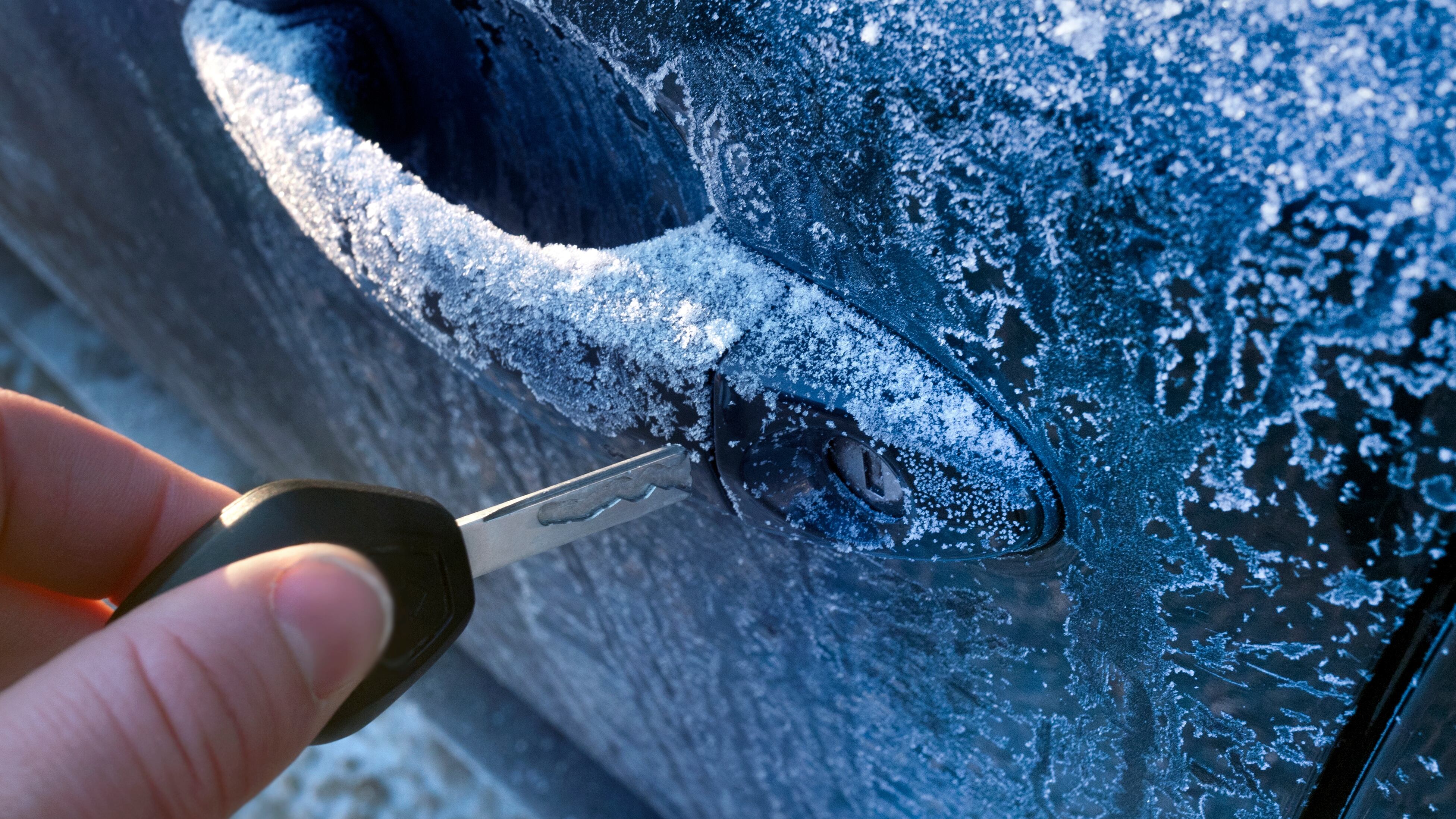 Unlocking a car door on a cold frozen winter morning