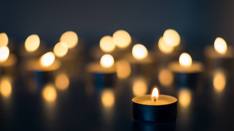 Flame of many candles burning on the background in blue and yellow color